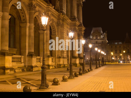 Vue de la nuit de l'éclairage de rue et le Musée du Louvre (Musée du Louvre). Ancien palais historique énorme collection d'art de logement, à partir de sculptures romaines de da Vinci Banque D'Images