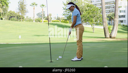 Golfeur femme la queue pour un putt Banque D'Images