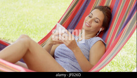 Pretty young woman relaxing in a hammock Banque D'Images