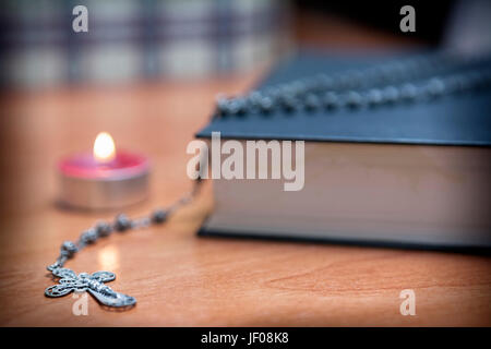 Chapelet et une sainte bible éclairage par une bougie rouge Banque D'Images