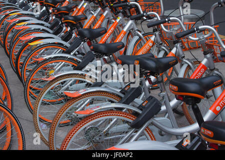 Des vélos à Public rues de Shenzhen, Guangdong, en république populaire de Chine ; l'opérateur Moovit - gris aluminium orange et bicyclettes Banque D'Images