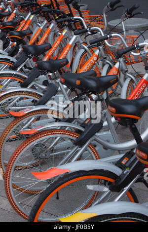 Des vélos à Public rues de Shenzhen, Guangdong, en république populaire de Chine ; l'opérateur Moovit - gris aluminium orange et bicyclettes Banque D'Images