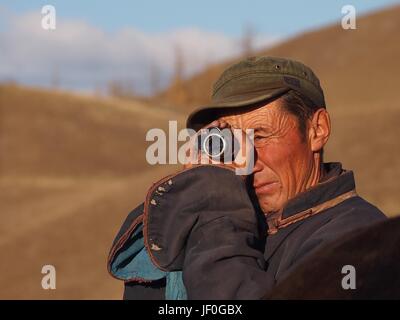 Gorkhi Terelj National Park, la Mongolie - 29 septembre 2016 : Un éleveur mongol utilise un télescope au sommet d'une colline à la recherche pour l'un de ses chevaux qui avaient bo Banque D'Images