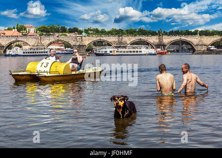 Vie quotidienne Prague été journée chaude touristes sur pédalo Prague gens hommes avec chien se baignant à Prague Vltava Pont Charles République tchèque Europe Banque D'Images