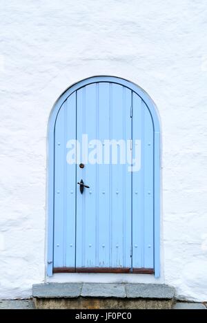 L'ancien phare porte bleue sur un mur blanc. Banque D'Images