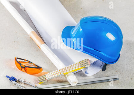 Casque, lunettes de sécurité et les bleus sur le site de construction. Bâtiment et outils engineereing close up. Banque D'Images