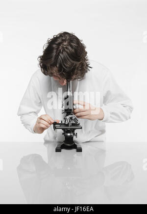 Un jeune chercheur scientifique inspecte certaines bactéries à l'aide d'un microscope Banque D'Images