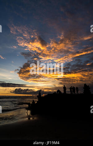 Silhouettes de personnes regardant le coucher du soleil sur la plage de Batu Bolong Canggu, Bali, Indonésie. Banque D'Images