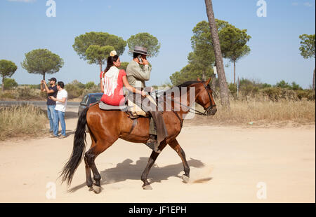 El Rocio, Espagne - juin 1, 2017 : Couple à cheval en tenue traditionnelle espagnole sur la route d'El Rocio pendant la Romeria 2017. Province de Huelva, Banque D'Images
