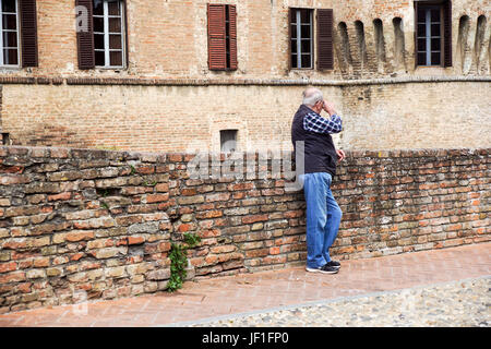 Parme, Italie - Avril 2017 : un homme âgé attend près du mur de brique Banque D'Images