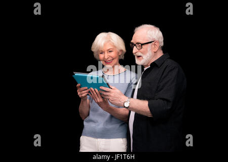 Smiling senior couple isolated on black Banque D'Images