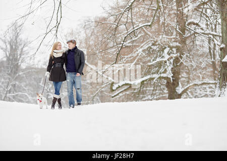 Couple walking dog Grâce à Winter Park Banque D'Images