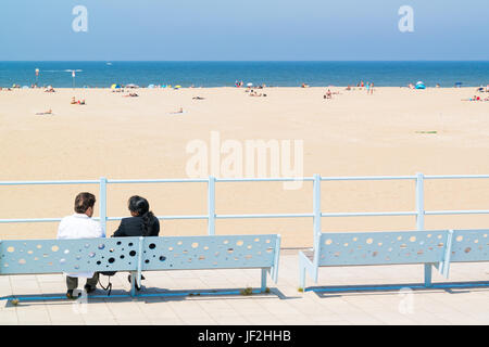 Couple sur un banc sur le boulevard à plus de plage et la mer du Nord station balnéaire de Scheveningen, à La Haye, Pays-Bas Banque D'Images