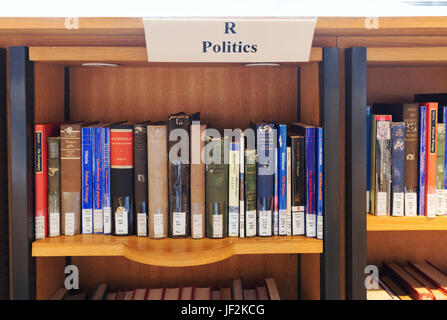 Livres de politique dans une bibliothèque sur les rayons de bibliothèque, England UK Banque D'Images