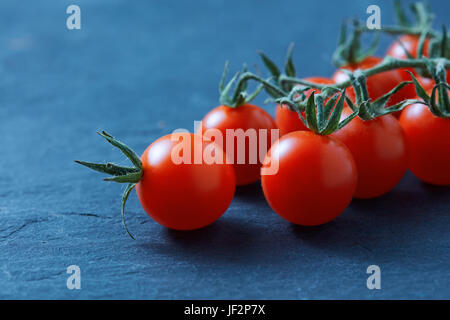 Tomates cerises fraîches mûres sur branch Banque D'Images
