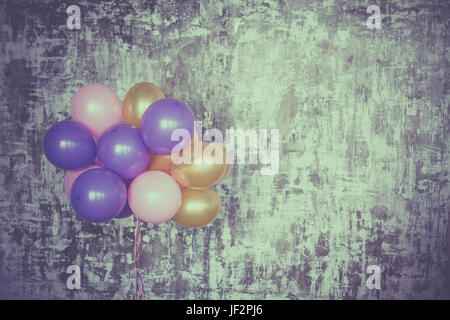 Bouquet de ballons lumineux contre un mur texturé. Copy space Banque D'Images