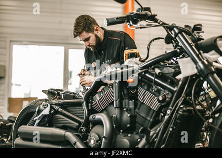 Mécanicien moto réparation vélo noir sport électronique. Beau travail de mécanicien en atelier de réparation automobile. Banque D'Images