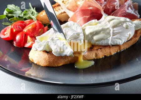 Les oeufs Bénédicte sur toast avec du jambon et de la sauce Banque D'Images