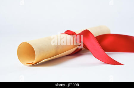 Close up d'un diplôme roulé faire défiler, attachés avec un ruban rouge. Banque D'Images