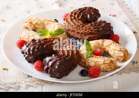 Cookies au chocolat et aux amandes en forme de fer à cheval avec les baies fraîches sur la table. L'horizontale Banque D'Images