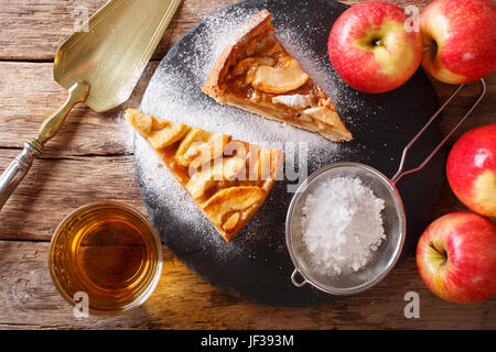 Morceau de tarte aux pommes faite maison avec du sucre en poudre sur une table horizontale vue du dessus. Banque D'Images