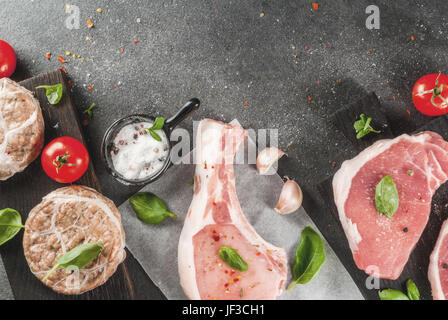 La viande biologique des matières premières. Sélection de plusieurs types de viande rouge : escalopes de porc sur l'os, des steaks et côtelettes de porc dans la grille de la graisse de porc. À partir d'ingrédients f Banque D'Images