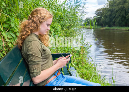 Young caucasian woman fonctionne mobile phone Banque D'Images