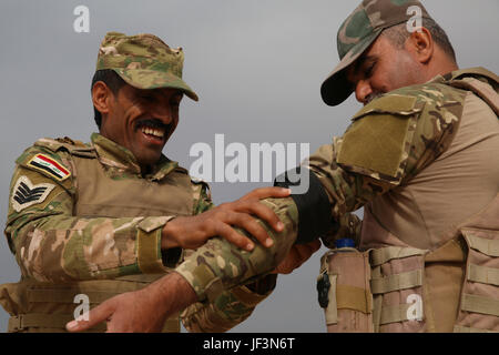 Des soldats irakiens avec 2e Bataillon, Brigade de commando, Anbar Operations Command, appliquer un garrot au cours d'un combat avec la Force cours lifesaver, Al-Taqaddum Combined Joint Task Force - Fonctionnement résoudre inhérent, en Iraq, le 17 avril 2017. Cette formation fait partie de l'ensemble de la CJTF-OIR renforcer les capacités des partenaires mission par la formation et de l'amélioration de la capacité des forces des combats en partenariat avec ISIS. Les GFIM-OIR est la Coalition mondiale pour vaincre ISIS en Iraq et en Syrie. (U.S. Marine Corps photo par le Cpl. Shellie Hall) Banque D'Images