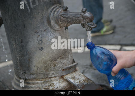 Une bouteille de remplissage avec l'eau potable dans la région de fontaine publique, Rome, Italie Banque D'Images