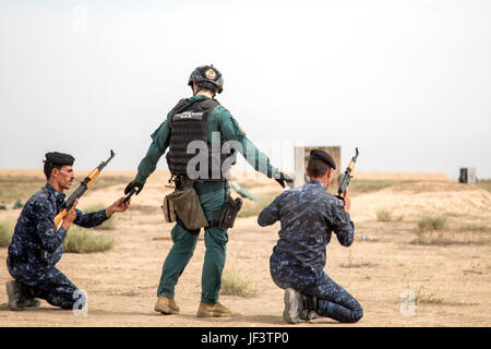 Un Guardia Civil espagnole formateur mains magazines de membres des forces de sécurité irakiennes au cours de formation au tir à courte portée à la gamme Besmaya complexe, l'Iraq, le 23 mai 2017. Cette formation fait partie de la Force opérationnelle interarmées combinée globale - Fonctionnement résoudre inhérent à renforcer les capacités des partenaires mission par la formation et de l'amélioration de la capacité des forces des combats en partenariat avec ISIS. Les GFIM-OIR est la Coalition mondiale pour vaincre ISIS en Iraq et en Syrie. (U.S. Photo de l'armée par le Cpl. Tracy McKithern) Banque D'Images