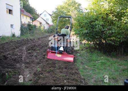 Le labourage du sol avec le tracteur Banque D'Images
