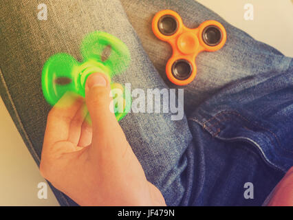 Trendy fidget spinner - personne tenant spinning fidget spinner en main, vue en gros, aux tons rétro Banque D'Images