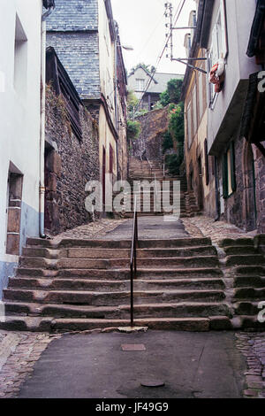 Quimper, Bretagne, France 1986 : retour sur l'ancienne rue de Quimper vols d'escaliers de pierre avec mains courantes grimper vers le haut. De chaque côté des marches est un petit coupé à l'aide de canal d'évacuation des eaux pluviales. Banque D'Images