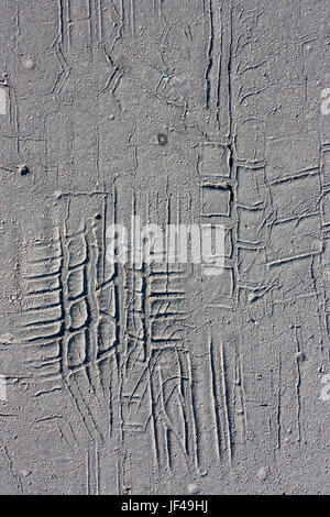 Les empreintes de pneus sur la vieille route d'asphalte fissuré en noir et blanc Banque D'Images