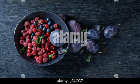 Figues et fruits rouges sur un bol Banque D'Images