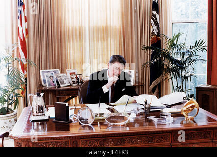 Le président Ronald Reagan à l'œuvre dans le bureau ovale. Banque D'Images