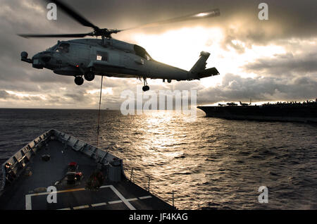 Un hélicoptère SH-60 Seahawk ramasse la cargaison de l'envol de l'USS Ford (FFG 54) au cours d'une opération de ravitaillement vertical avec le porte-avions USS JOHN C. STENNIS (CVN 74). DoD photo de Maître de 2e classe Oscar Espinoza, Marine américaine. Banque D'Images