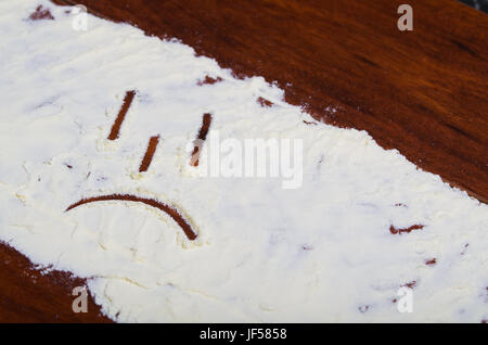 Un visage triste drawed stevia en poudre sur fond de bois. Banque D'Images