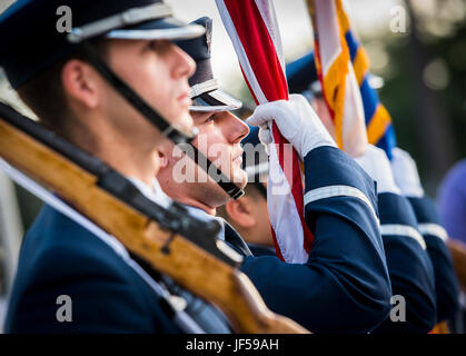 Un membre de la 96th test Wing Honor Guard tient le drapeau américain pendant l'hymne national lors de la 32e course annuelle Gate to Gate à la base aérienne d'Eglin, en Floride, honorant la tradition militaire américaine et la participation communautaire. Banque D'Images