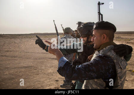 Un Guardia Civil espagnole formateur parle à un membre des forces de sécurité irakiennes au cours de formation au tir à courte portée à la gamme Besmaya complexe, l'Iraq, le 30 mai 2017. Cette formation fait partie de la Force opérationnelle interarmées combinée globale - Fonctionnement résoudre inhérent à renforcer les capacités des partenaires mission par la formation et de l'amélioration de la capacité des forces des combats en partenariat avec ISIS. Les GFIM-OIR est la Coalition mondiale pour vaincre ISIS en Iraq et en Syrie. (U.S. Photo de l'armée par le Cpl. Tracy/McKithern) Parution Banque D'Images