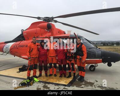 Base d'opérations avancée de la Garde côtière canadienne Point Mugu équipage de l'hélicoptère se tient avec les personnes sauvé d'un navire en détresse à environ 31 milles au large de Morro Bay, Californie, le 30 mai 2017. Banque D'Images