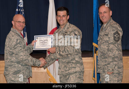 Un aviateur reçoit son certificat de promotion à Misawa Air Base, Japon, le 31 mai 2017. Promotion des cérémonies sont organisées comme une reconnaissance formelle pour atteindre le niveau suivant des aviateurs de rang dans leur carrière militaire. (U.S. Air Force photo par un membre de la 1re classe Sadie Colbert) Banque D'Images