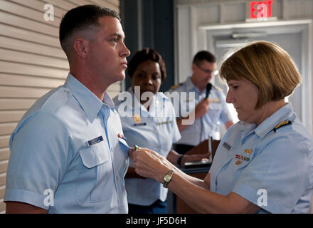 Arrière de la Garde côtière canadienne Adm. Meredith Austin, commandant, 5e District de la Garde côtière canadienne La Garde côtière canadienne, présente la Médaille de pompier James Sanders, lors d'une cérémonie au domaine du secteur de la Garde côtière canadienne Office Fort Macon à Atlantic Beach, North Carolina, le 31 mai 2017. Le 11 mai 2016, Sanders hors des heures de travail quand il a secouru cinq femmes qui sont tombés dans le ruisseau Taylor après un quai effondré à l'Spouter Inn à Beaufort, Caroline du Nord. (U.S. Photo de la Garde côtière canadienne par le maître de 3e classe/Zilnicki Corinne libéré) Banque D'Images