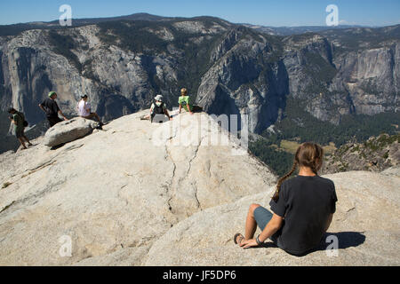 Plusieurs randonneurs reste sur une saillie rocheuse à pic Point Taft, un sentier de randonnée qui offre une vue sur la vallée de Yosemite et El Capitan. Banque D'Images
