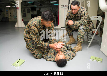 170601-N-NJ416-0016 de l'OCÉAN PACIFIQUE (1 juin 2017) Hospital Corpsman Seaman Apprentice Jose Cisneros indique à lance le Cpl. Cody Souza (à gauche) et lance le Cpl. Cameron Rathje au cours d'un combat en cours de rassemblement de troupes lifesaver à bord du navire d'assaut amphibie USS America (LHA 6). ). L'Amérique est actuellement en cours d'exercice de Certification (CERTEX) dans le cadre de la troisième et dernière phase des qualifications pour leur déploiement à venir. L'Amérique du groupe amphibie est composé de plus de 1 800 marins et 2 600 Marines américains affectés à la station d'navire de débarquement amphibie USS Pearl Harbor (LSD Banque D'Images