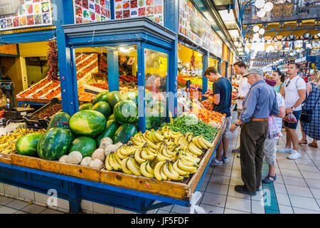 Étal de fruits colorés avec une belle exposition de bananes, melons et fruits dans le hall du marché central couvert (Vasarcsarnok), Pest, Budapest, Hongrie Banque D'Images