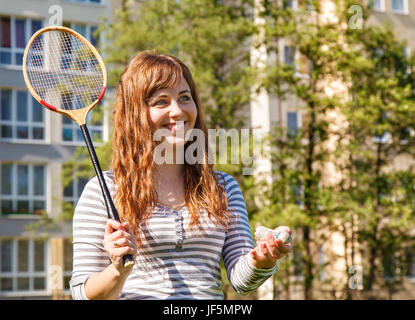 Jeune femme belle jouer au badminton dans le parc aux beaux jours d'été Banque D'Images