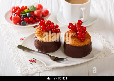 Muffins au chocolat et à la noix de coco, petits fruits et café au lait sur la table horizontale. Banque D'Images