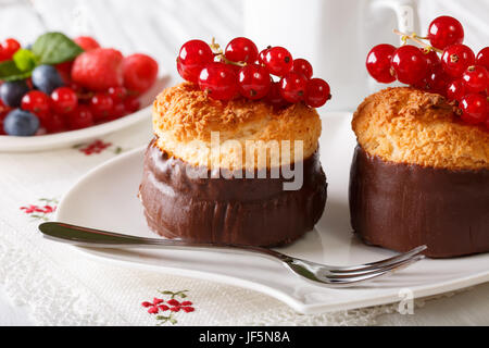 Muffins au chocolat et à la noix de coco savoureux avec groseille close-up sur la table horizontale. Banque D'Images