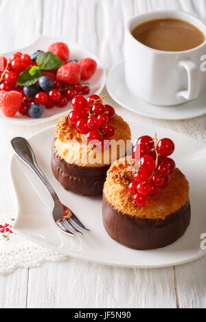 Muffins noix de coco magnifique avec de groseille rouge et de café sur la table verticale. Banque D'Images